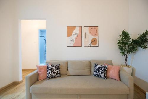 a couch in a living room with paintings on the wall at 2 bedroom apartement in the center of cairo in Cairo