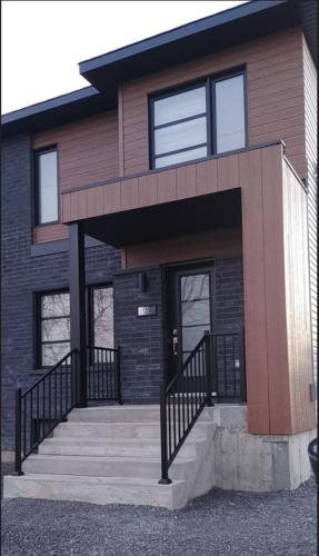 a brick house with a staircase in front of it at L'Éclat de Valleyfield in Salaberry de Valleyfield