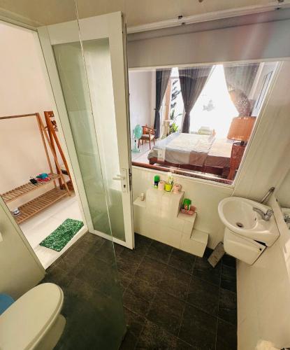 a bathroom with a toilet and a sink and a bedroom at sunset beach house in Phú Quốc