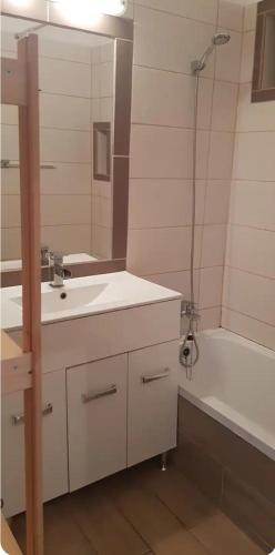 a bathroom with a sink and a tub and a mirror at Cozy flat near Kazinczy downtown in Budapest