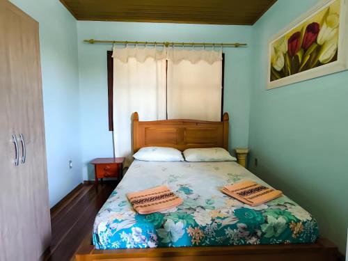 a bedroom with a bed with two pillows on it at Pousada do Nestor in São Gabriel