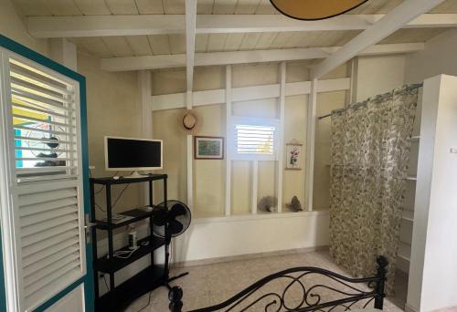 a living room with a television and a window at Les marches de Paulina in Sainte-Luce