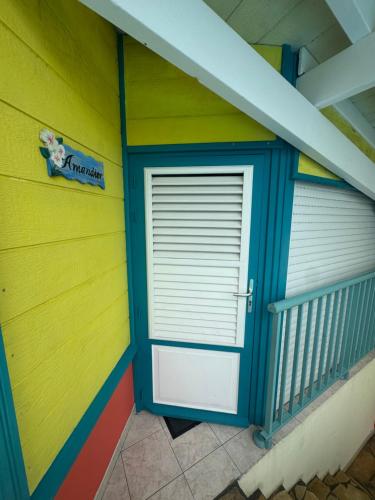 a garage door in a house with a colorful wall at Les marches de Paulina in Sainte-Luce