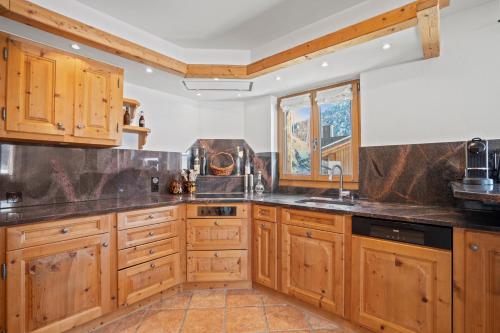 a kitchen with wooden cabinets and a sink at A&Y Wellness Chalet Didi in Davos