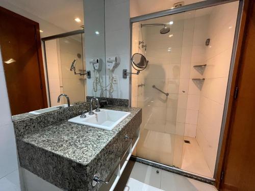a bathroom with a sink and a shower at Flat na Beira do Lago in Brasilia