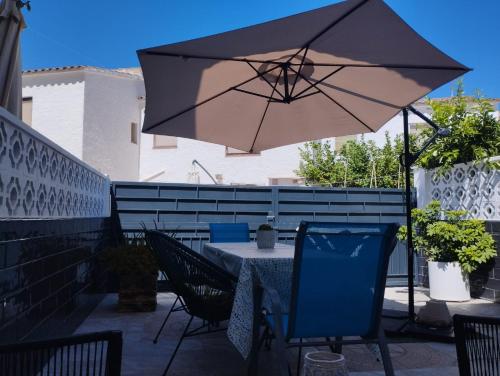 a table and chairs with an umbrella on a patio at Casa Gares in Peñíscola