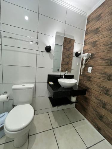 a bathroom with a toilet and a sink at Familien Haus Pousada in Pomerode