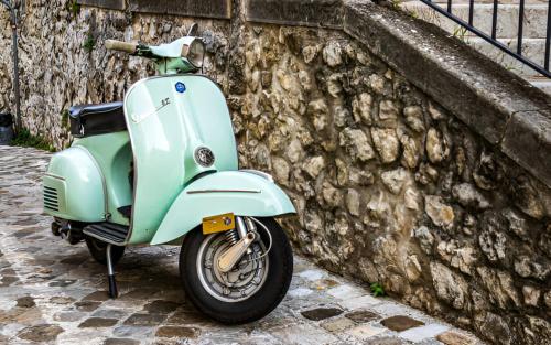 a scooter parked next to a stone wall at Palazzo Brandano Hotel in Petroio