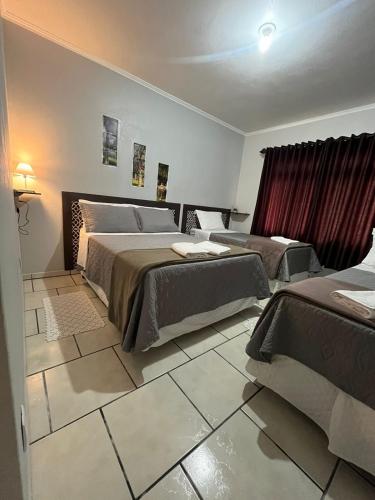a hotel room with two beds and a window at Familien Haus Pousada in Pomerode