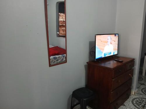 a television sitting on top of a dresser with a mirror at Quarto próximo ao Inpa e Ufam in Manaus
