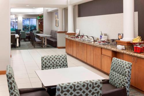 a restaurant with a counter and chairs and tables at Residence Inn by Marriott Chicago Lake Forest/Mettawa in Mettawa
