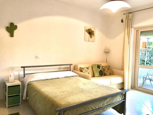 Un dormitorio con una cama y un sofá y una ventana. en Pizzo Beach Studio 162G, en Pizzo