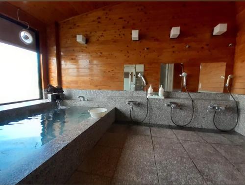 baño con piscina y espejo en 初聚 SHOSHU hotel, en Yamanakako