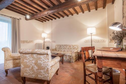 a living room with chairs and a wooden table at Palazzo Brandano Hotel in Petroio