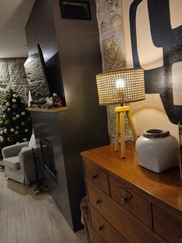 a room with a table with a lamp on a dresser at Villa Dos Santos - Gerês Country House in Geres