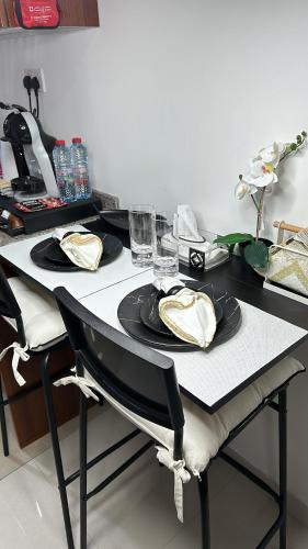 a table with two plates and glasses on it at NEW!! Apartment next to Airport & Yas island in Abu Dhabi