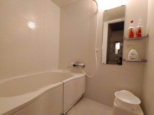 a white bathroom with a tub and a toilet at Yuririan in Kyoto