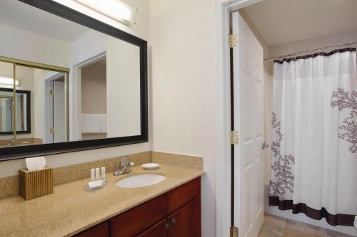 a bathroom with a sink and a mirror at Residence Inn Joplin in Joplin