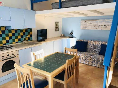 a kitchen and living room with a table and a couch at Casetta San Giovanni in Pizzo