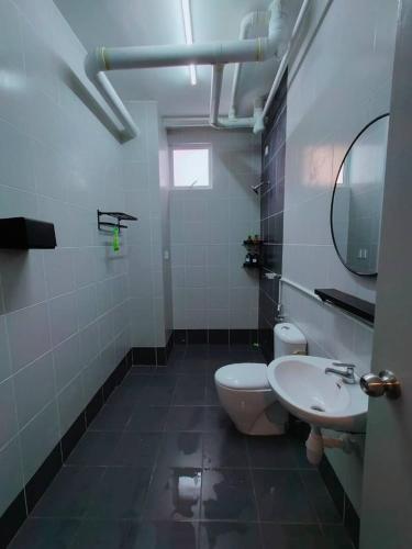 a bathroom with a toilet and a sink and a mirror at Teratak Seri Indah in Kuala Terengganu