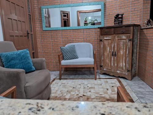 a living room with a couch and a mirror at Casa de Veraneio in Capão da Canoa