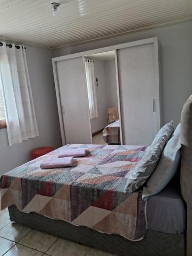 a bedroom with a bed with a quilt on it at Casa de Veraneio in Capão da Canoa