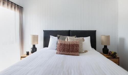 a bedroom with a white bed with pillows and two lamps at Whitton Malt House in Whitton