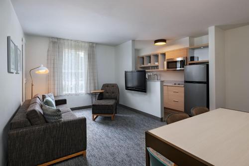 a living room with a couch and a kitchen at TownePlace Suites by Marriott College Station in College Station