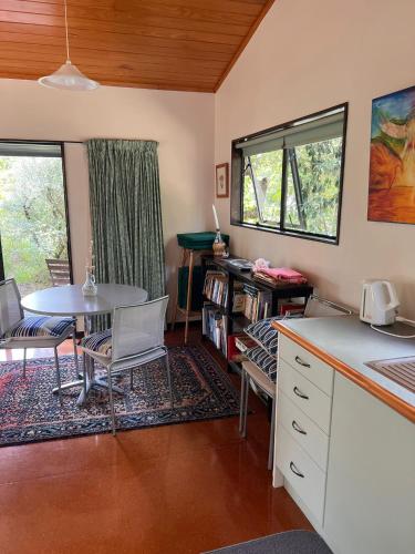 a kitchen with a table and a table and chairs at Whangapoua Paradise in Whangapoua