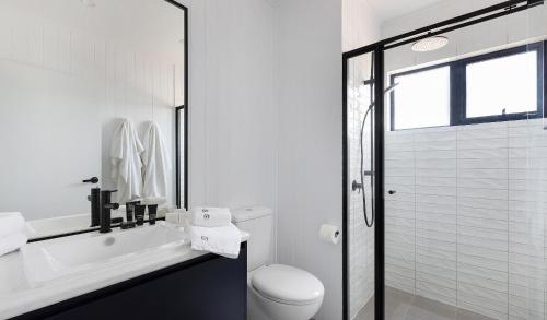 a white bathroom with a toilet and a shower at Whitton Malt House in Whitton