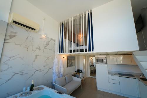 a kitchen and living room with a couch and a sink at Villa Bono Jacuzzi & Spa in Saint-Laurent-du-Var