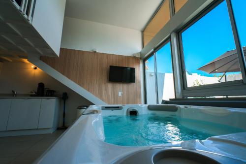 a bathroom with a tub with blue water in it at Villa Bono Jacuzzi & Spa in Saint-Laurent-du-Var