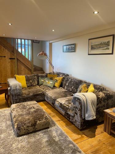 a living room with a couch with yellow pillows at Meagill Cottage Sleeps 4 with Hot Tub & Parking in Otley