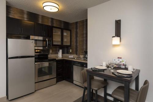 a kitchen with a table and a white refrigerator at Residence Inn Durango Downtown in Durango
