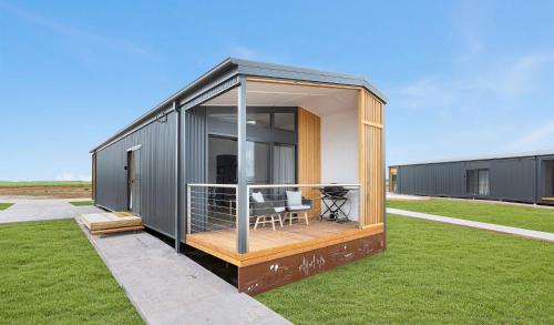 a small house with a deck on a lawn at Whitton Malt House in Whitton