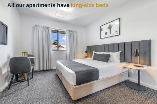 a bedroom with a king size bed and a desk at Hudson Parap in Darwin