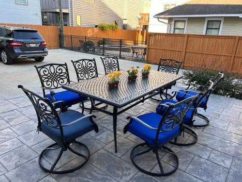 a table and chairs with flowers on a patio at MyCrib Houston Hostel in Houston