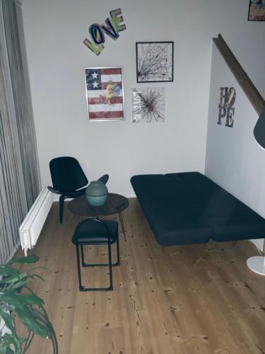 a living room with a blue couch and a chair at Moderne og centralt rækkehus i Herning in Herning