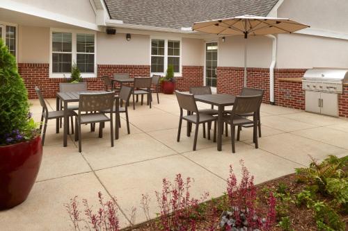 a patio with tables and chairs and an umbrella at Residence Inn Asheville Biltmore in Asheville