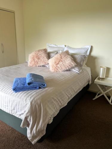 a bed with two pillows and two towels on it at Views Forever in Whangarei Heads