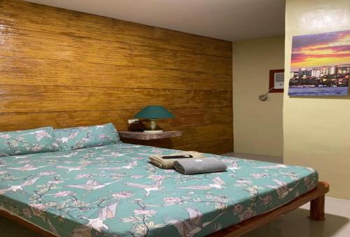a bedroom with a bed with a wooden head board at RedDoorz @ Piamonte Apartelle Santo Tomas Batangas in Santo Tomas