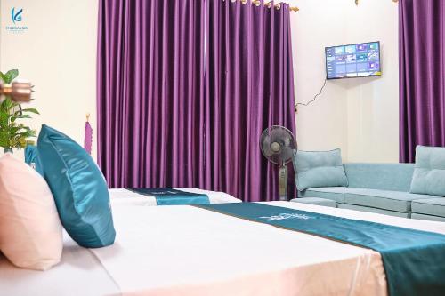 a hotel room with a bed and purple curtains at Kim's Family Hotel in Ha Long