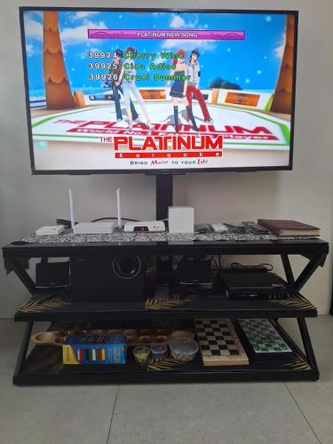 a tv sitting on top of a shelf with a monitor at Seafront Residences Vacation Home in Batangas City