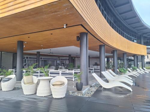 a row of white chairs sitting in front of a building at Seafront Residences Vacation Home in Batangas City