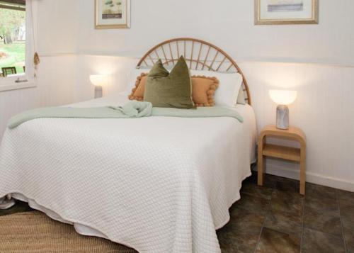 a bedroom with a large white bed with two lamps at Rustic Hills Getaway in Bickley