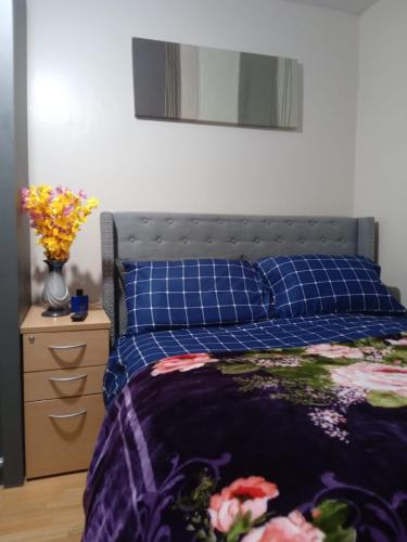 a bedroom with a bed with a blue comforter and a dresser at Exclusive Double Bedroom in a Gorgeous Shared Flat with Top Access in Plumstead