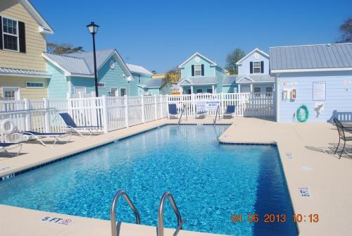 a swimming pool in front of some houses at Contemporary 2-BR cottage, 2 Blocks to Beach in Myrtle Beach