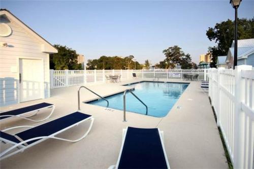 a swimming pool with two lounge chairs on a patio at Contemporary 2-BR cottage, 2 Blocks to Beach in Myrtle Beach