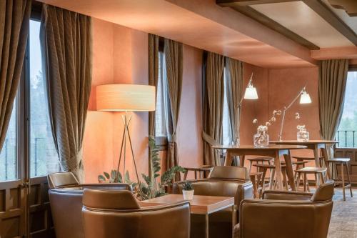 a restaurant with brown chairs and tables and windows at AC Hotel Ciudad de Toledo by Marriott in Toledo