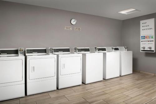 a row of white washers and dryers in a room at SpringHill Suites by Marriott Boise ParkCenter in Boise